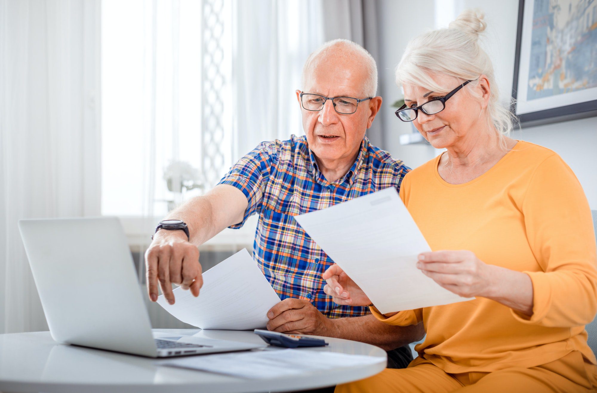 Senior filling documents for their Part C or D Annual Notice of Change using a laptop at home.