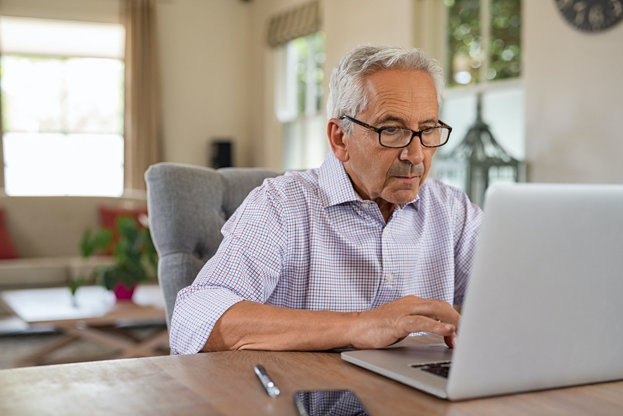 Senior man researching benefits and drawbacks to getting medicare if still working at 65.