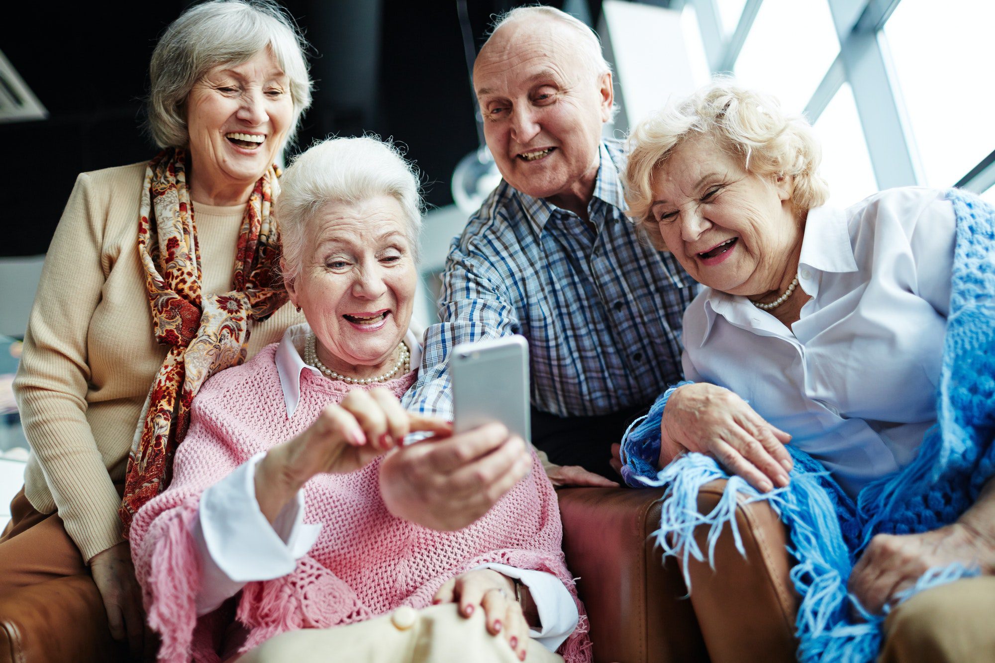 Senior man using smartphone to show friends the new care compare tool.