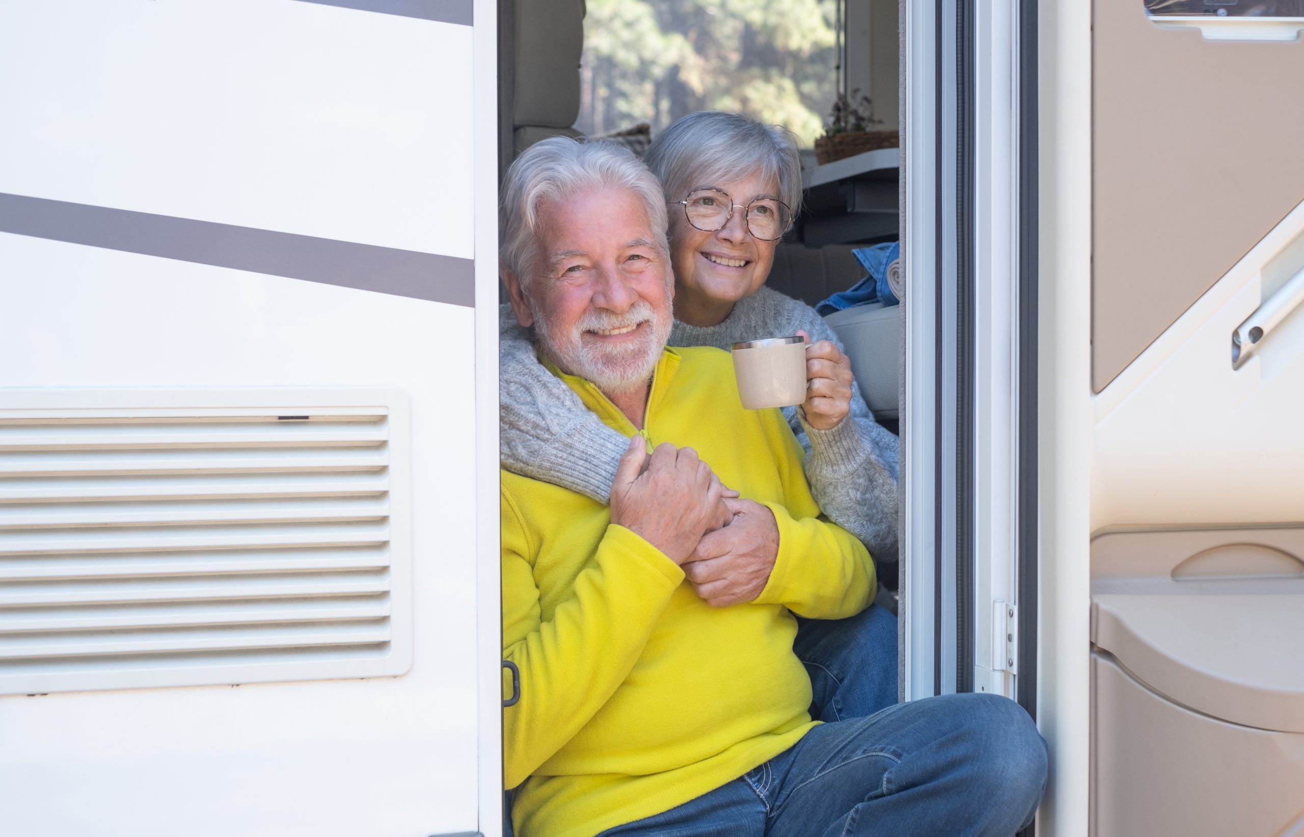 Happy senior couple in RV discussing what Medicare Plan E is.