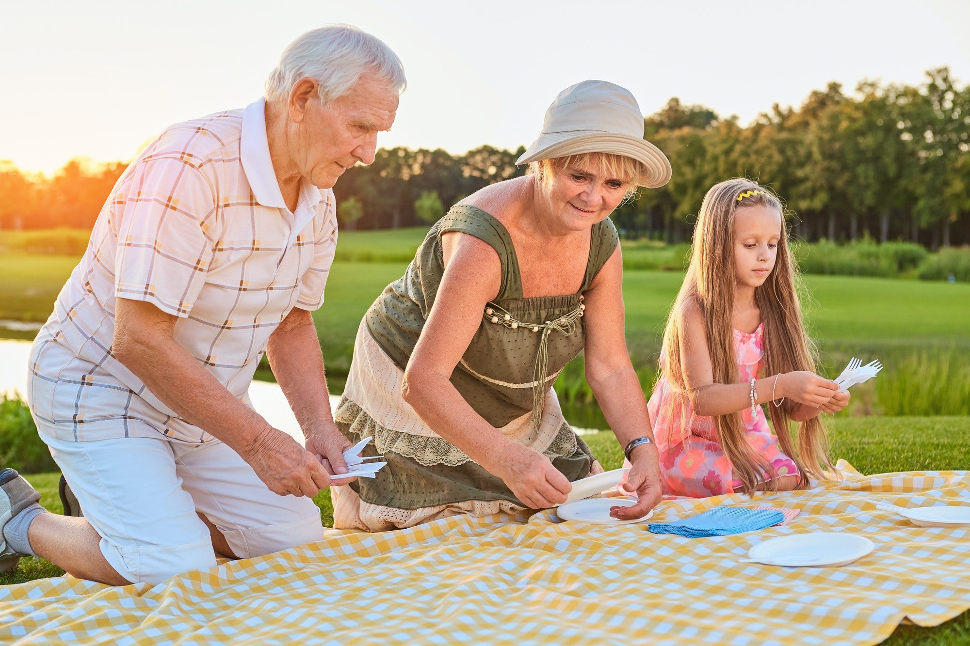Senior people with granddaughter enjoy picnic as they discuss which Medicare Supplement company is right for them.