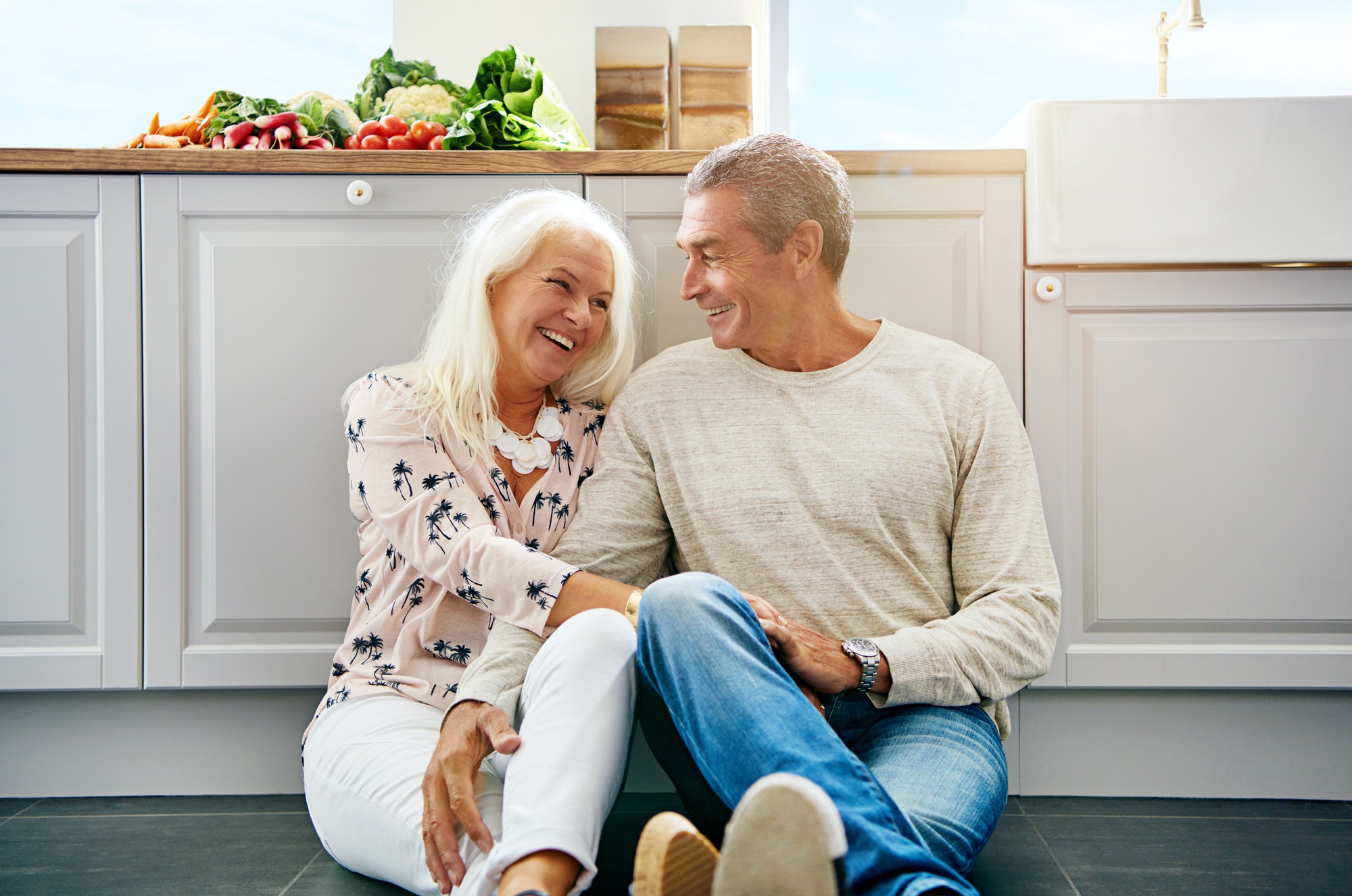 Elderly couple chatting on a kitchen floor. Medicare and HSAs: How to Avoid Excise Tax Penalties