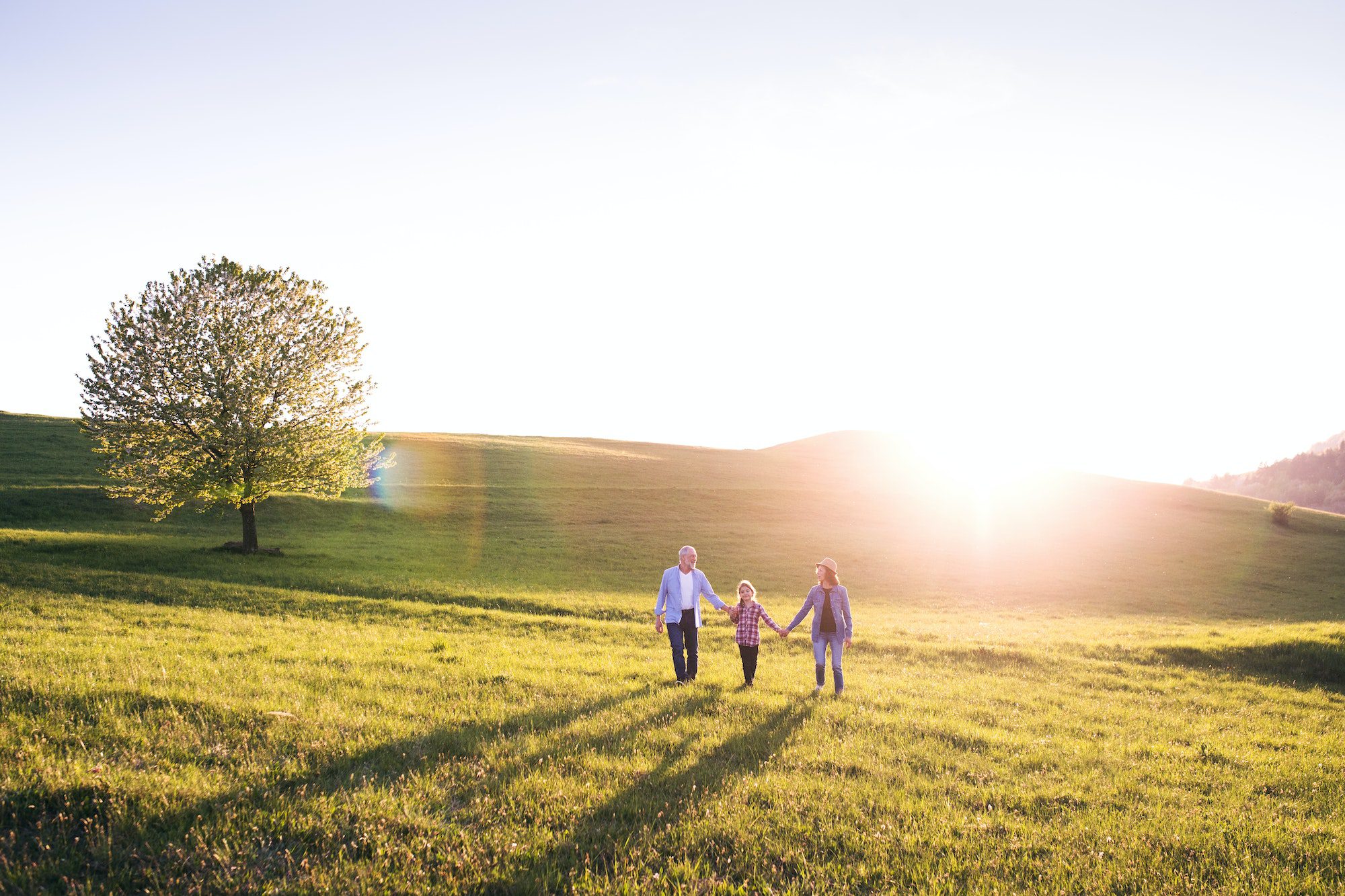 Senior couple with granddaughter outside in spring nature during AEP